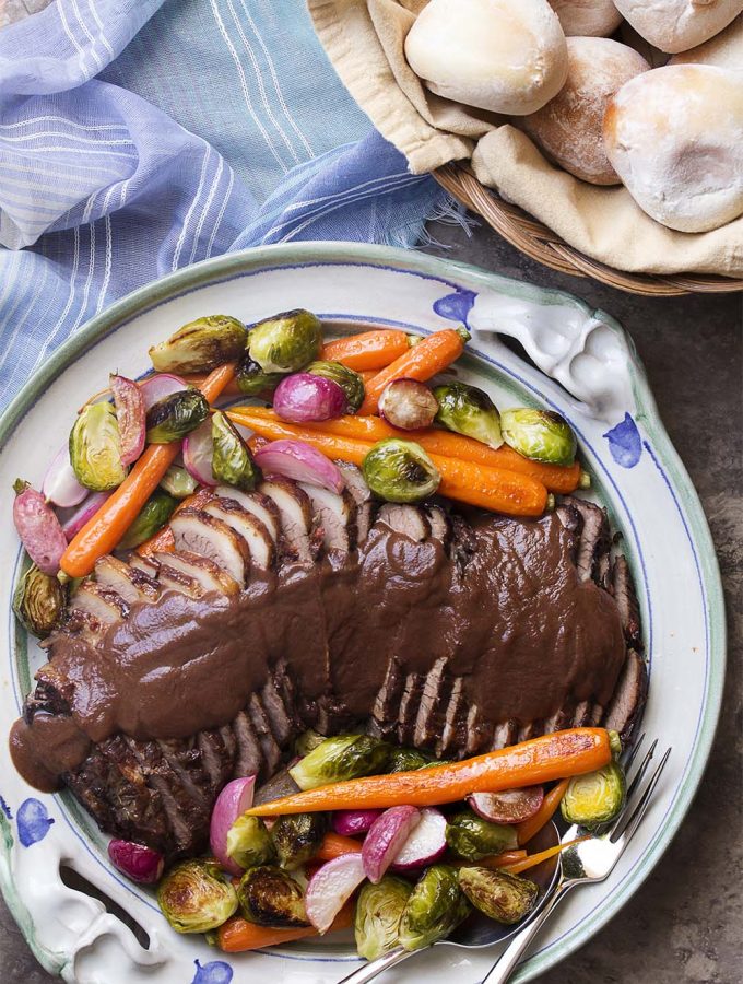 For a delicious and fork-tender oven braised beef brisket, cook it low and slow in red wine and onions. Then let it cool for easy slicing and puree the sauce for a thick and rich onion gravy. Great holiday roast!