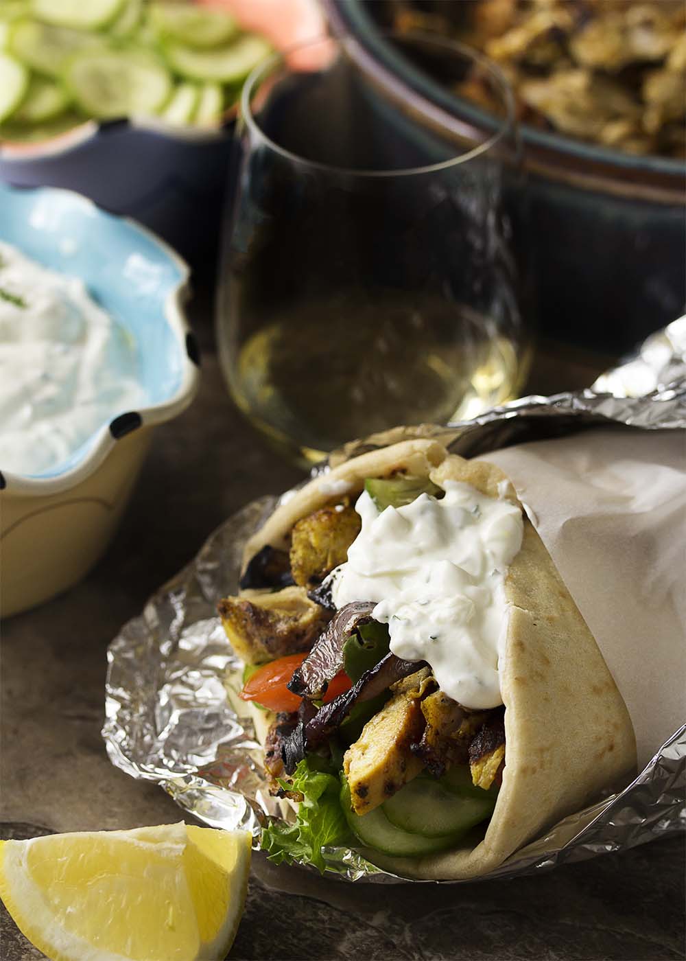 Chicken shawarma pita wrap filled with chicken, veggies, and yogurt sauce and wrapped in foil.