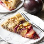 Ripe sliced plums, crisp grapes, and toasted walnuts are wrapped in a simple, flaky pie crust and brushed with honey in this rustic French plum galette tart.