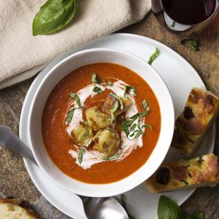 Comfort food at its best! Roasted red pepper and tomato soup is easy, creamy, and perfect for weeknight dinner or for company. Great with fried croutons, slices of crusty bread, or grilled cheese. | justalittlebitofbacon.com #souprecipes #tomatosoup #tomatoes #redpeppers #comfortfood