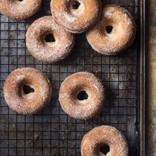Skip the mess of deep frying and make baked cider donuts instead! These easy fall treats coated in cinnamon sugar are perfect dunked into apple cider for a morning snack or for dessert. | justalittlebitofbacon.com #donuts #doughnuts #applecider #fallrecipes #applerecipes #bakeddonuts