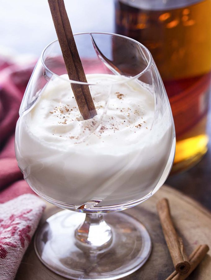 Hot spiced bourbon milk punch is a simple and cozy winter cocktail full of warming spices and sweetened with just a touch of maple syrup. Top with whipped cream to make it extra special! Great as for the holidays or as a Christmas drink. | justalittlebitofbacon.com #cocktails #bourbon #holidayrecipes #hotdrink #winterrecipes