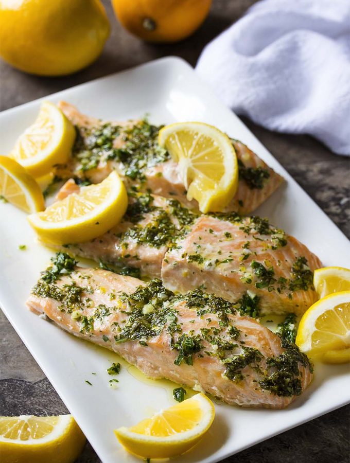 Turn on your oven to make the best tender slow roasted salmon! Served with a lemon herb sauce, it's simple to make and a great part of a healthy diet. | justalittlebitofbacon.com #mediterraneanrecipes #salmon #salmonrecipes #fishrecipes #easydinners