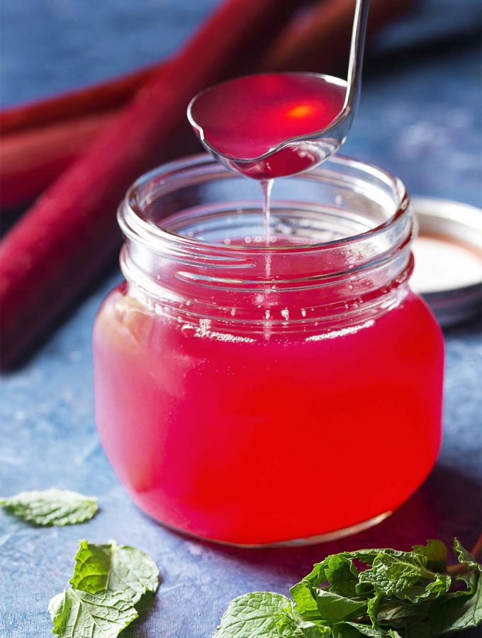 Easy to make, this homemade rhubarb syrup has so many uses! Rhubarb simple syrup can be poured over pancakes, made into cocktails and drinks, served over ice cream, added to pound cake, and more. | justalittlebitofbacon.com #rhubarb #springrecipes #dessertrecipes #syrup #simplesyrup