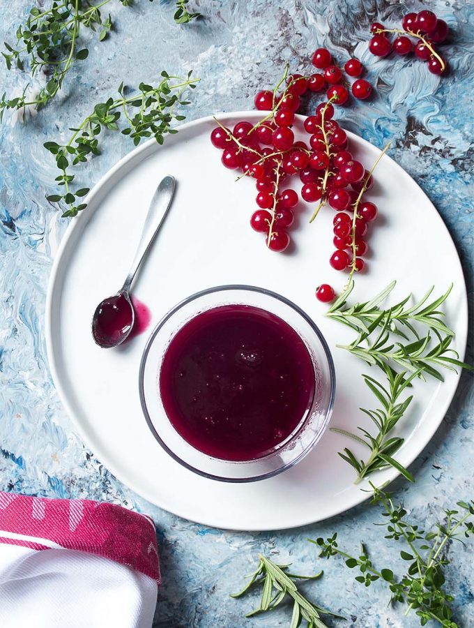 A great way to enjoy in season fresh red currants is to make a sweet and tangy red currant sauce perfect for pork, venison, duck, salmon, chicken, and more! | justalittlebitofbacon.com #sauces #redcurrants #savorysauce