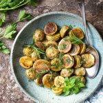Baby yukon gold potatoes are sliced in half and tossed with olive oil and salt and finished with fresh herbs in these crispy oven roasted herb potatoes. They are an easy and delicious recipe for Thanksgiving, Christmas, and other holidays. | justalittlebitofbacon.com #potatoes #roastedpotatoes #thanksgivingrecipes #holidayrecipes
