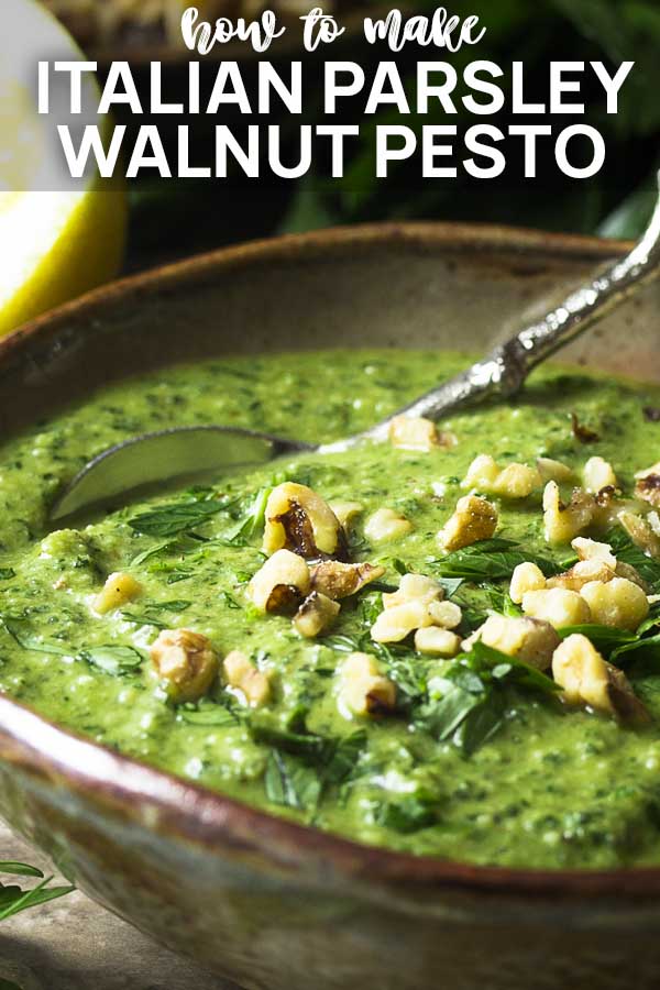 Pesto in a brown serving bowl with spoon with text overlay - Italian Parsley Walnut Pesto.