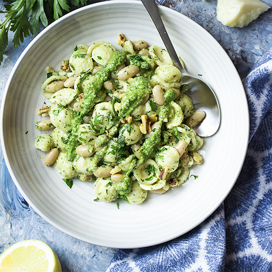 You'll love this simple and fast vegetarian dinner! Pesto is tossed with pasta and white beans and a little pasta water for a creamy sauce and a satisfying meal. Use store-bought pesto for a super quick meal or make your own pesto. | justalittlebitofbacon.com #italianrecipes #vegetarian #vegetariandinners #pasta #pastarecipes