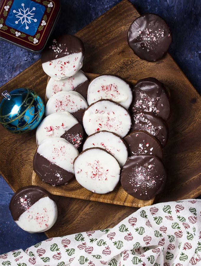For a Christmas cookie sure to be the hit of the holiday party, you'll love my double chocolate peppermint cookies! Chocolate cookies are dipped in white and dark chocolate flavored with peppermint oil and topped with crushed candy canes. | justalittlebitofbacon.com #christmasrecipes #christmascookies #holidayrecipes #chocolaterecipes #peppermint #chocolate #cookies