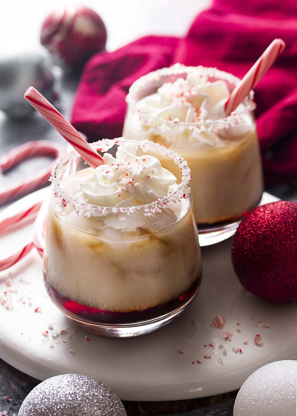 Close up of peppermint white Russians with Kahlua and vodka layer topped by a milk layer.