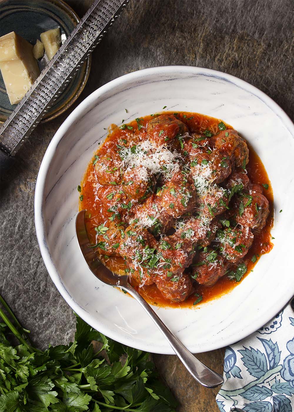 Top view of a serving bowl of Italian meatballs in tomato sauce and parmesan.