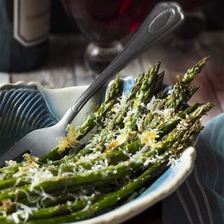 For an easy and quick side dish, cook my oven roasted asparagus with parmesan! This delicious Mediterranean recipe makes delicious use of spring produce with crispy cheese, tender veggies, and a sprinkle of balsamic. | justalittlebitofbacon.com #italianrecipes #italianfood #mediterraneanfood #springrecipes #asparagus #spring