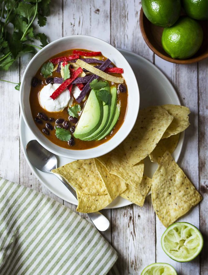 My spicy vegetarian tortilla soup is easy, healthy, AND quick! This is a pantry meal you can make in 30 minutes for a delicious and satifying dinner. Rich broth, smoky chipotles, plenty of black beans, and crunchy tortilla chips. | justalittlebitofbacon.com #mexicanfood #mexicanrecipes #souprecipes #pantryrecipes #soup #mexican #blackbeans #vegetariandinners