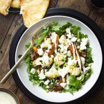 Roasted cauliflower and sweet potato combine with tender French green lentils and peppery arugula in this delicious warm salad all topped with a creamy yogurt and tahini dressing. Perfect for a healthy Mediterranean vegetarian dinner! | justalittlebitofbacon.com #saladrecipes #mediterraneanfood #lentilrecipes #frenchlentils #cauliflower #sweetpotatoes