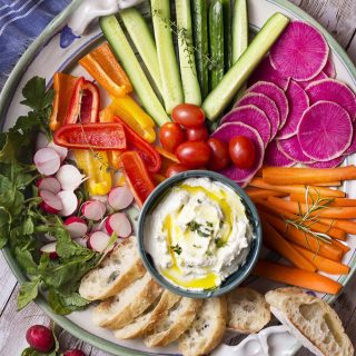 Dip your favorite crudites and crackers into my easy garlic goat cheese spread! This cold herbed appetizer can be made in minutes and use just a few ingredients. | justalittlebitofbacon.com #appetizerrecipes #diprecipes #goatcheese #appetizers #dips #spreads