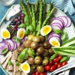 Canned tuna packed in a jar of olive oil and fresh asparagus are featured in my spring nicoise salad! Set it up on a large platter for the best presentation and enjoy all the crisp vegetables, soft boiled eggs, and creamy potatoes all drizzled with a simple lemon dressing. | justalittlebitofbacon.com #saladrecipes #frenchrecipes #springrecipes #spring #salad #frenchfood #asparagus