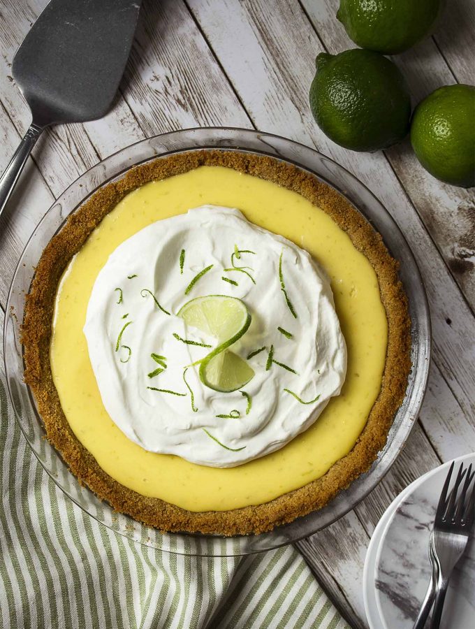 For a classic summertime treat make the best homemade key lime pie! Crunchy sweet graham cracker crust, creamy tart filling of condensed milk and lime, and a dollop of whipped cream on top. | justalittlebitofbacon.com #dessertrecipes #pierecipes #pie #dessert #keylimepie
