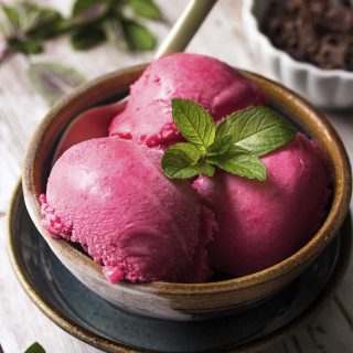 Learn how to make homemade orange raspberry frozen yogurt. It is tart and sweet and simple to make! You'll love churning up this cold summertime treat anytime you have craving. | justalittlebitofbacon.com #icecream #frozenyogurt #summerrecipes #dessertrecipes #raspberries #yogurt
