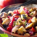 Make the most of flavorful summer tomatoes with this amazing Italian panzanella salad! Perfectly ripe tomatoes, smokey grilled bread, plenty of basil, and light and tangy vinaigrette all come together for a side dish you'll love all season long. | justalittlebitofbacon.com #italianfood #summerrecipes #saladrecipes #tomatoes #salads #grillingrecipes #veganfood