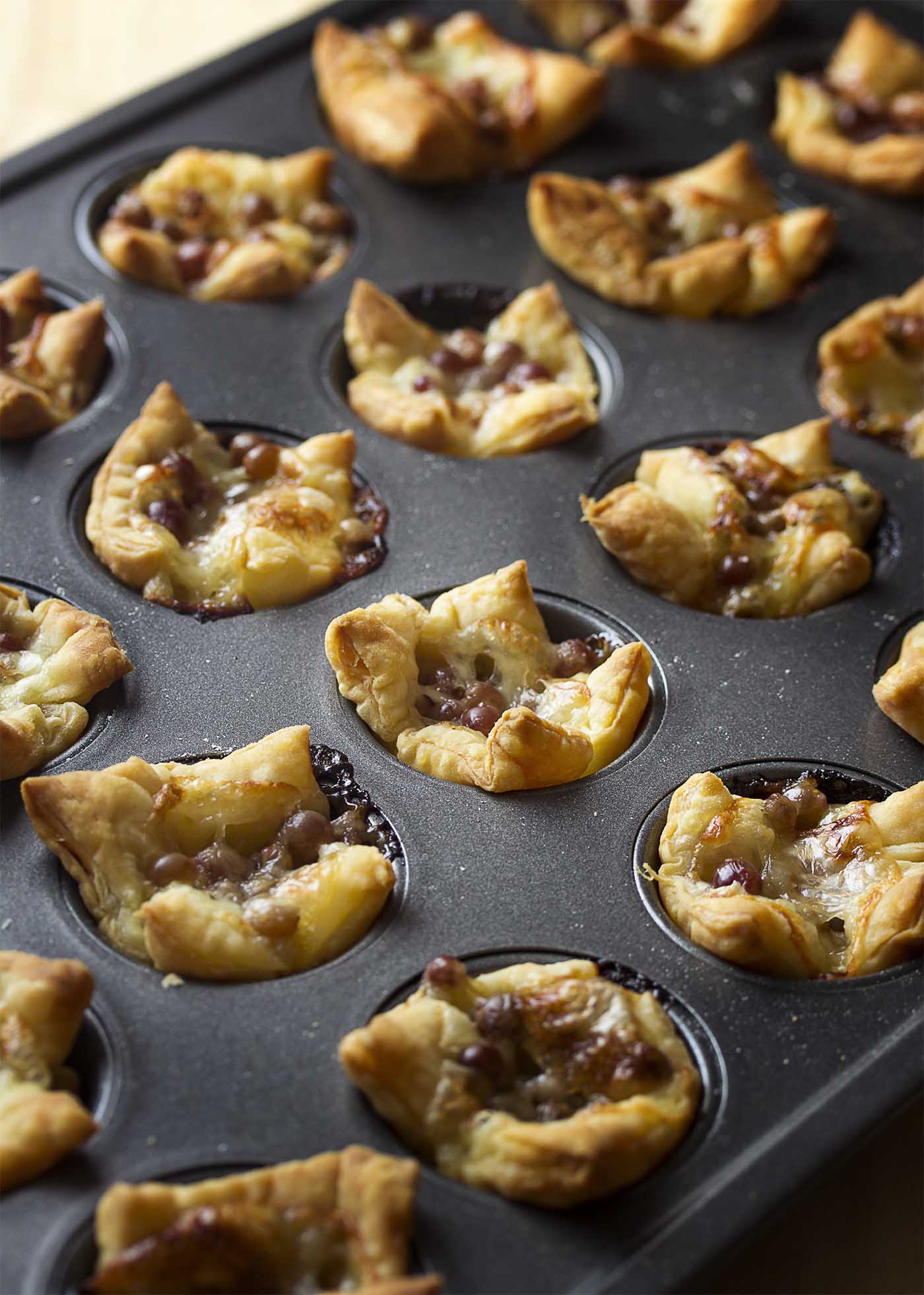 Baked grape and brie tarts in a mini muffin pan.