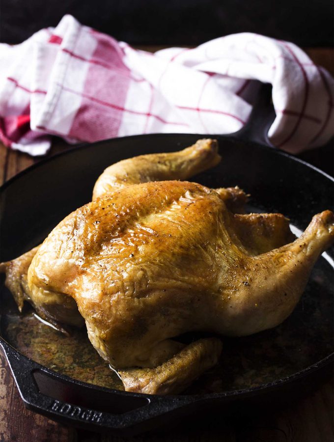 Small holiday gathering or Sunday dinner? Try my easy cast iron roast chicken! Less than an hour in oven and you'll have browned skin and juicy meat. Try my recipe for easy cast iron roast chicken! Less than an hour in oven and you'll have browned skin and juicy meat with no fuss. Perfect for Thanksgiving, Christmas, Easter, and more! | justalittlebitofbacon.com #roastchicken #castiron #easydinner #thanksgiving #christmas #easter #sundaydinner