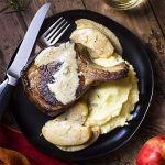 This simple stove top meal of pork chops pan seared in a cast iron skillet and served with an apple cream sauce is a perfect date night dinner! Brine ahead of time, fry in a hot pan, and make a quick sauce while the chops rest. | justalittlebitofbacon.com