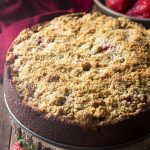 Enjoy a slice of moist and delicious banana strawberry cake! This crumb topped coffee cake with fruit filling is perfect for breakfast, snacks, or dessert. | justalittlebitofbacon.com #cakerecipes #dessertrecipes #coffeecake #bananacake #strawberries #bananas