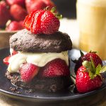 An update to a classic! My strawberry shortcake has homemade chocolate buttermilk biscuits and is topped by a rich bourbon cream sauce. | justalittlebitofbacon.com