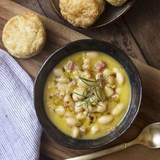 My creamy Tuscan white bean soup is flavored with pancetta and rosemary and uses canned cannellini beans for delicious and easy weeknight dinner. | justalittlebitofbacon.com