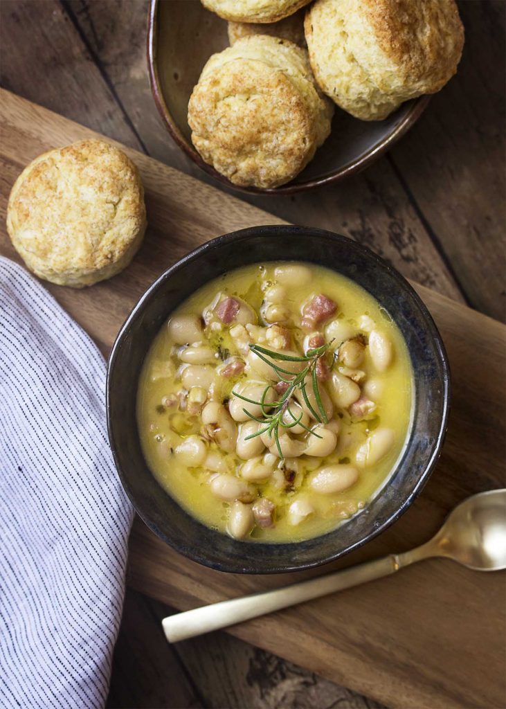 Top view of a bowl of Italian white bean soup with pancetta and rosemary.