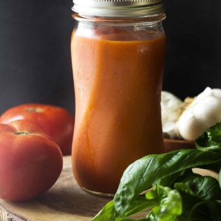 My homemade roasted tomato sauce is made with fresh garden tomatoes slow roasted in the oven to concentrate the flavors! Perfect for pasta. Simple to make and easy to freeze or can. | justalittlebitofbacon.com